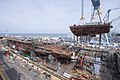 A crane moves the lower stern into place on the nuclear-powered aircraft carrier USS John F. Kennedy (CVN 79). (34649699544).jpg